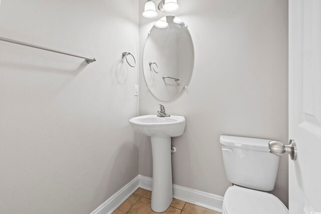 bathroom with toilet, tile patterned flooring, and baseboards