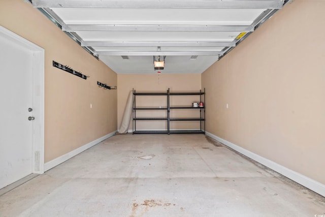 garage with a garage door opener and baseboards