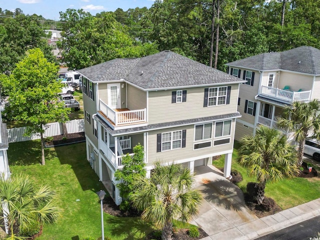 view of front of home with roof with shingles, a carport, concrete driveway, and a balcony