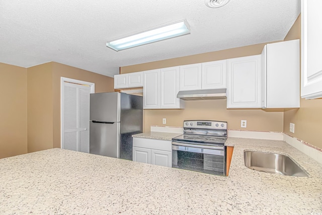 kitchen featuring appliances with stainless steel finishes, under cabinet range hood, a sink, white cabinetry, and a textured ceiling