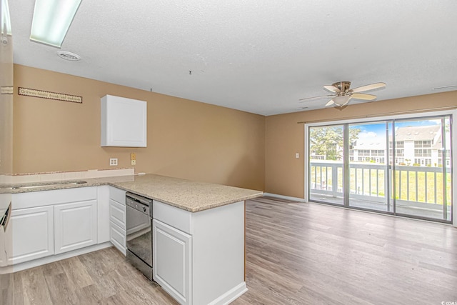 kitchen featuring dishwashing machine, light wood-style flooring, a peninsula, a ceiling fan, and white cabinetry