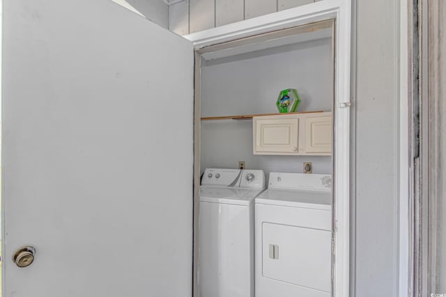 laundry area with independent washer and dryer and cabinet space