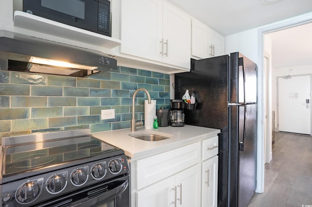 kitchen featuring black appliances, a sink, backsplash, and white cabinets