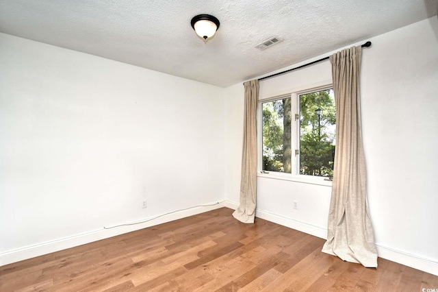 816 Kittiwake Ln, Murrells Inlet, SC 29576 - empty room featuring light wood-type flooring, baseboards, and a textured ceiling