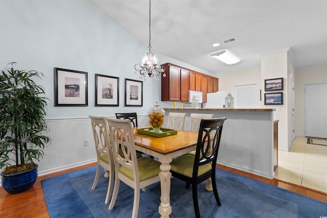 5840 Longwood Dr Unit 303, Murrells Inlet, SC 29576 - dining area with a chandelier, wood finished floors, a wainscoted wall, ornamental molding, and baseboards