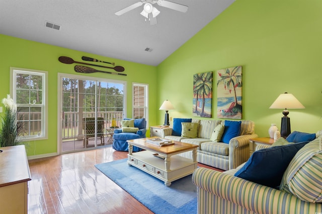 living area featuring ceiling fan, wood finished floors, baseboards, and high vaulted ceiling