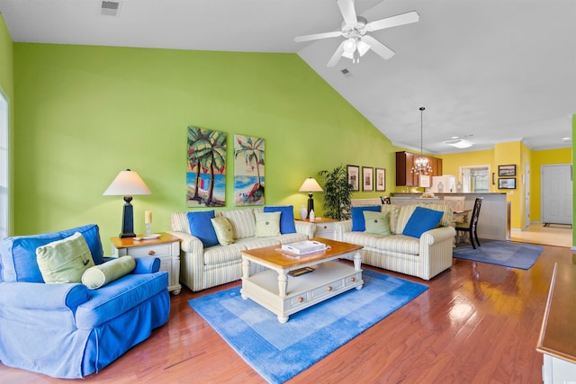 living area featuring a chandelier, wood finished floors, ceiling fan, and high vaulted ceiling