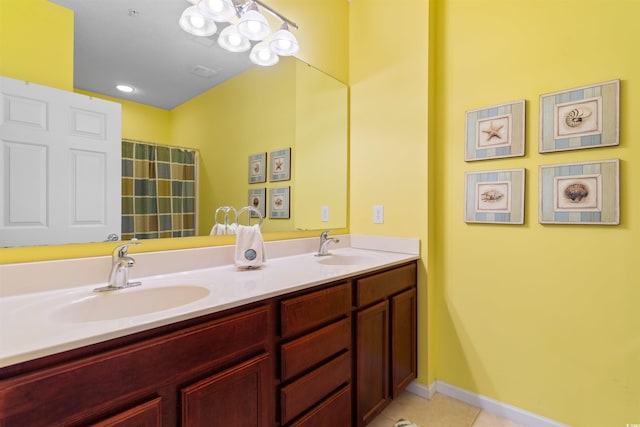 full bath featuring tile patterned flooring, double vanity, and baseboards