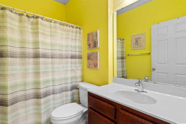bathroom featuring toilet, vanity, and a shower with curtain