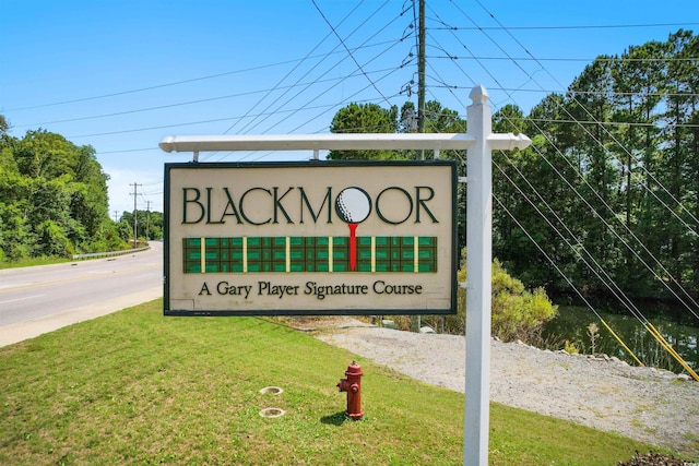 community / neighborhood sign with a yard
