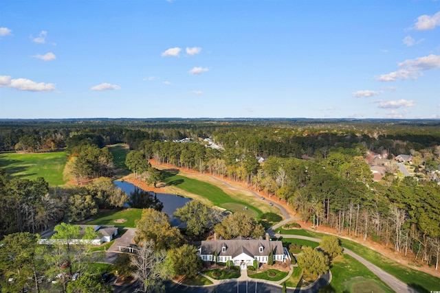 view of property location featuring a forest, a nearby body of water, and a golf club