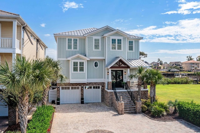 4832 Williams Island Dr, Little River, SC 29566 - coastal home featuring a standing seam roof, metal roof, an attached garage, and decorative driveway