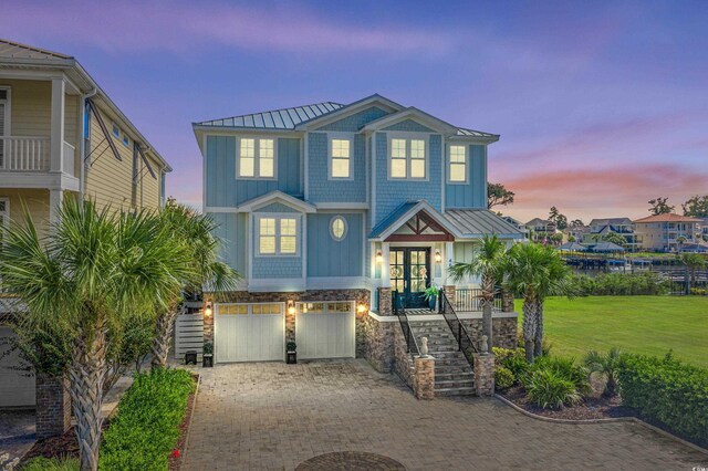 4832 Williams Island Dr, Little River, SC 29566 - coastal inspired home featuring a standing seam roof, stairway, metal roof, french doors, and an attached garage