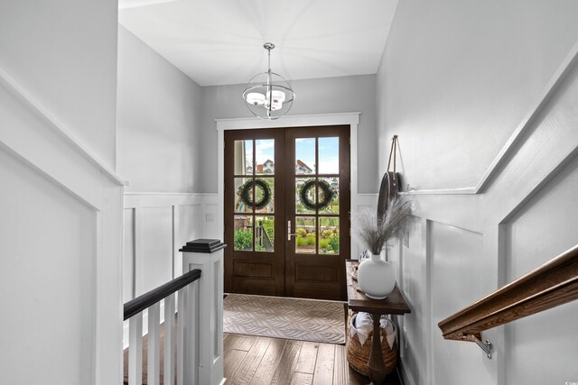 4832 Williams Island Dr, Little River, SC 29566 - foyer entrance featuring wainscoting, wood finished floors, a chandelier, french doors, and a decorative wall