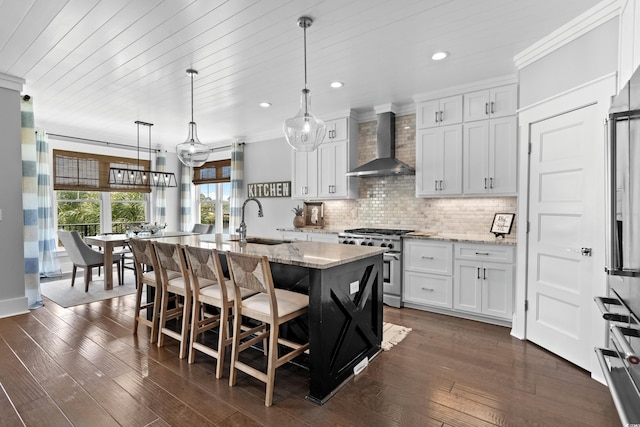 4832 Williams Island Dr, Little River, SC 29566 - kitchen featuring wall chimney exhaust hood, high end appliances, a sink, white cabinetry, and decorative backsplash