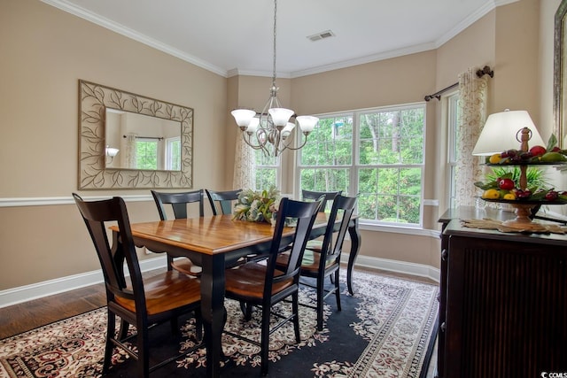 dining room with baseboards, wood finished floors, a chandelier, and crown molding