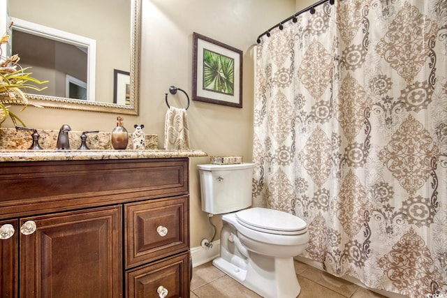 bathroom with tile patterned floors, toilet, vanity, baseboards, and curtained shower