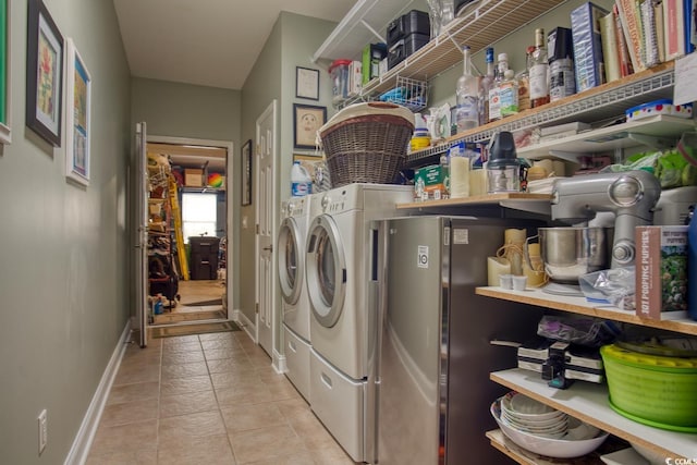 washroom featuring separate washer and dryer, baseboards, and light tile patterned floors