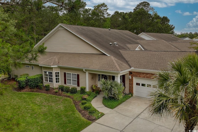 view of front of property featuring a garage, roof with shingles, concrete driveway, and a front lawn