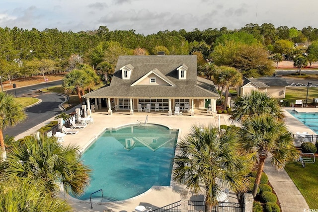 community pool with a patio area and fence