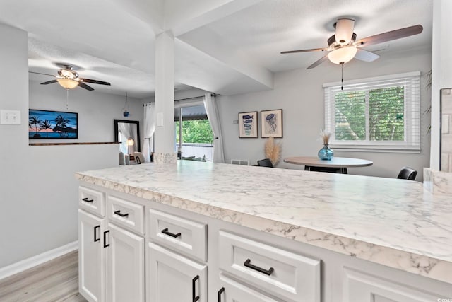 10301 N Kings Hwy Unit 10-4, Myrtle Beach, SC 29572 - kitchen featuring a ceiling fan, light countertops, light wood-style flooring, white cabinets, and baseboards