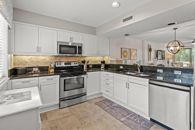 306 Westbury Ct Unit 2-B, Myrtle Beach, SC 29572 - kitchen featuring appliances with stainless steel finishes, a sink, white cabinets, a textured ceiling, and recessed lighting