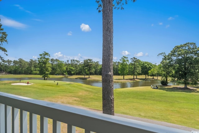 view of community with a water view, view of scattered trees, golf course view, and a lawn