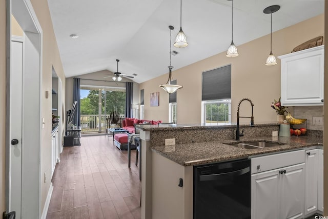 kitchen with black dishwasher, a sink, white cabinets, a peninsula, and lofted ceiling