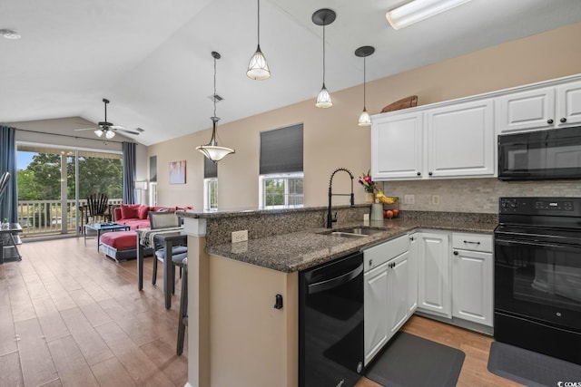 kitchen featuring black appliances, a sink, light wood-style floors, a peninsula, and open floor plan