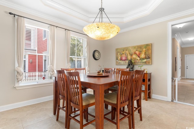 dining area with crown molding, a raised ceiling, light tile patterned floors, and baseboards