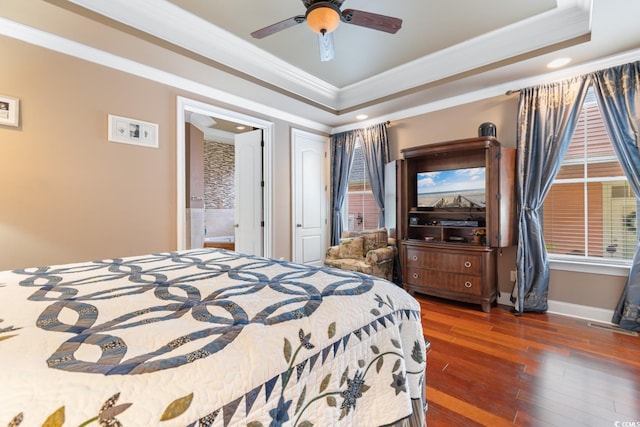 bedroom with ornamental molding, a tray ceiling, wood-type flooring, recessed lighting, and baseboards