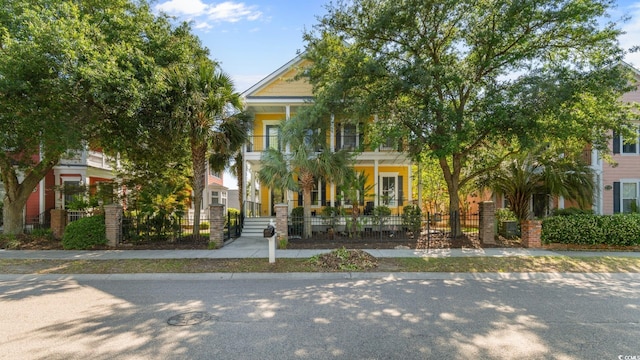 obstructed view of property featuring a fenced front yard and covered porch