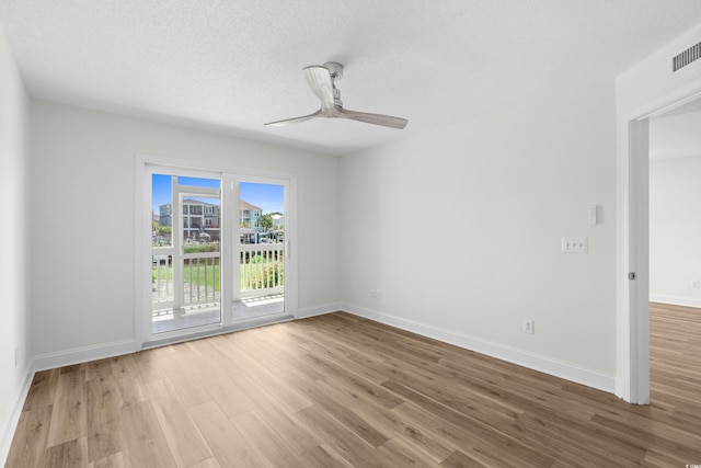 spare room featuring wood finished floors, baseboards, and a ceiling fan