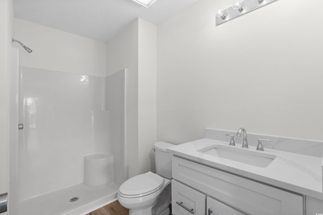 bathroom with a shower, toilet, vanity, and wood finished floors