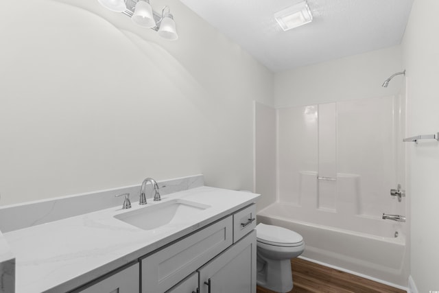 full bath featuring wood finished floors, toilet, vanity, and shower / bath combination