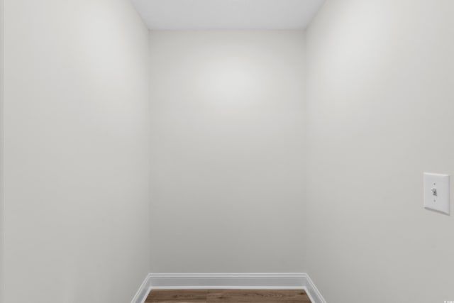 washroom featuring wood finished floors and baseboards