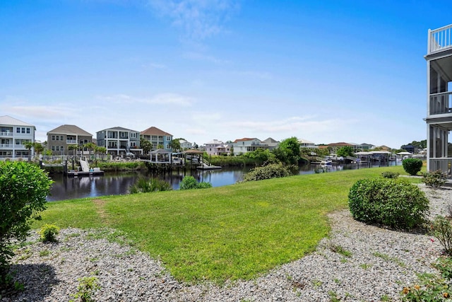 view of green lawn with a water view and a residential view