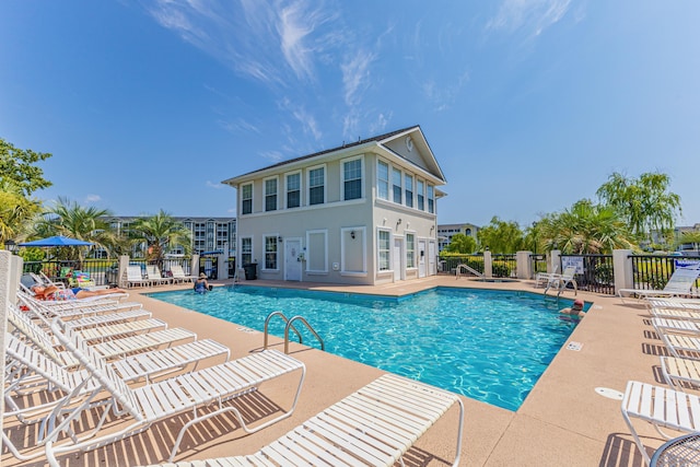 community pool featuring fence and a patio