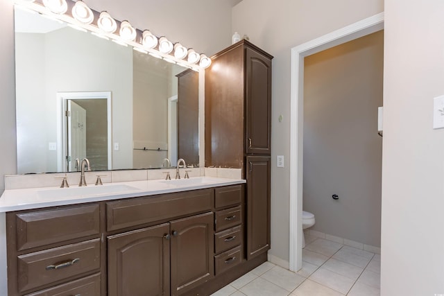 bathroom featuring tile patterned floors, toilet, and double vanity