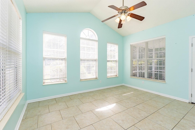 empty room featuring ceiling fan, lofted ceiling, tile patterned floors, and baseboards