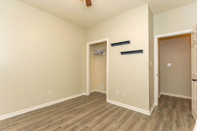 unfurnished bedroom with wood finished floors, baseboards, a closet, and ceiling fan