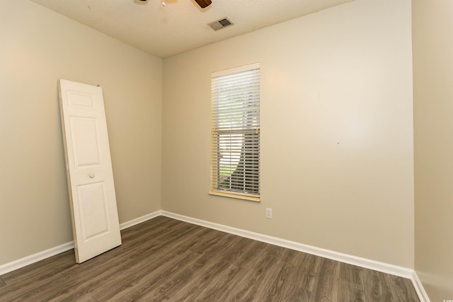 unfurnished room featuring dark wood-style flooring, baseboards, and a ceiling fan
