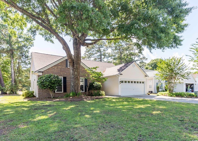 view of front of property with an attached garage, a front lawn, concrete driveway, and brick siding