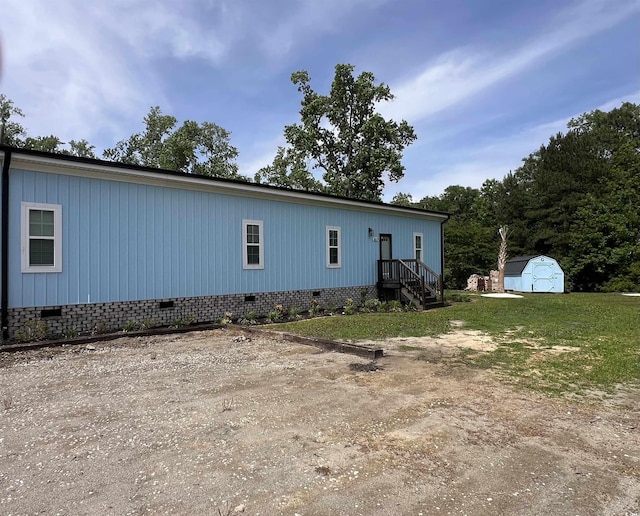 view of front of house with crawl space, a storage unit, and an outdoor structure