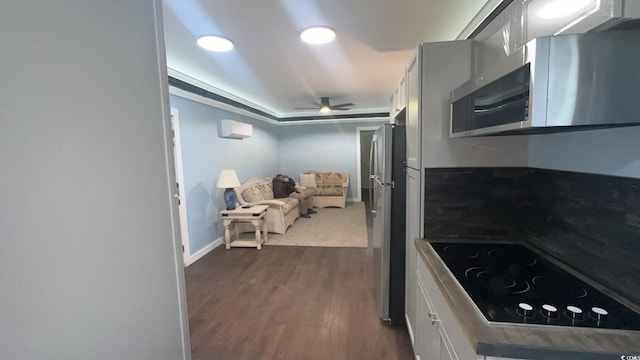 kitchen with appliances with stainless steel finishes, dark wood-style flooring, a ceiling fan, and white cabinets