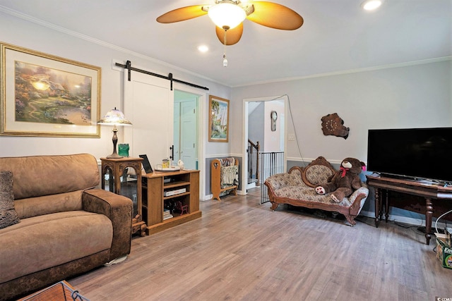living room featuring a barn door, wood finished floors, ornamental molding, ceiling fan, and recessed lighting