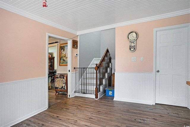 spare room with a wainscoted wall, wood finished floors, stairs, and crown molding
