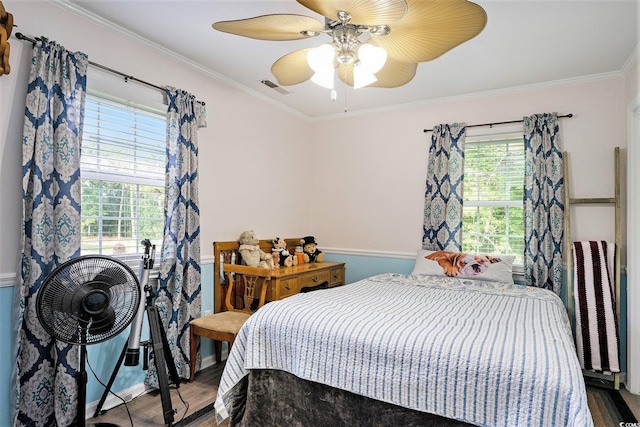 bedroom featuring multiple windows, wood finished floors, crown molding, a ceiling fan, and baseboards