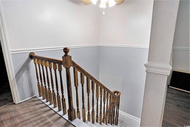 stairway featuring wood finished floors and a ceiling fan