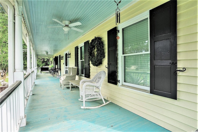 wooden terrace featuring covered porch and ceiling fan